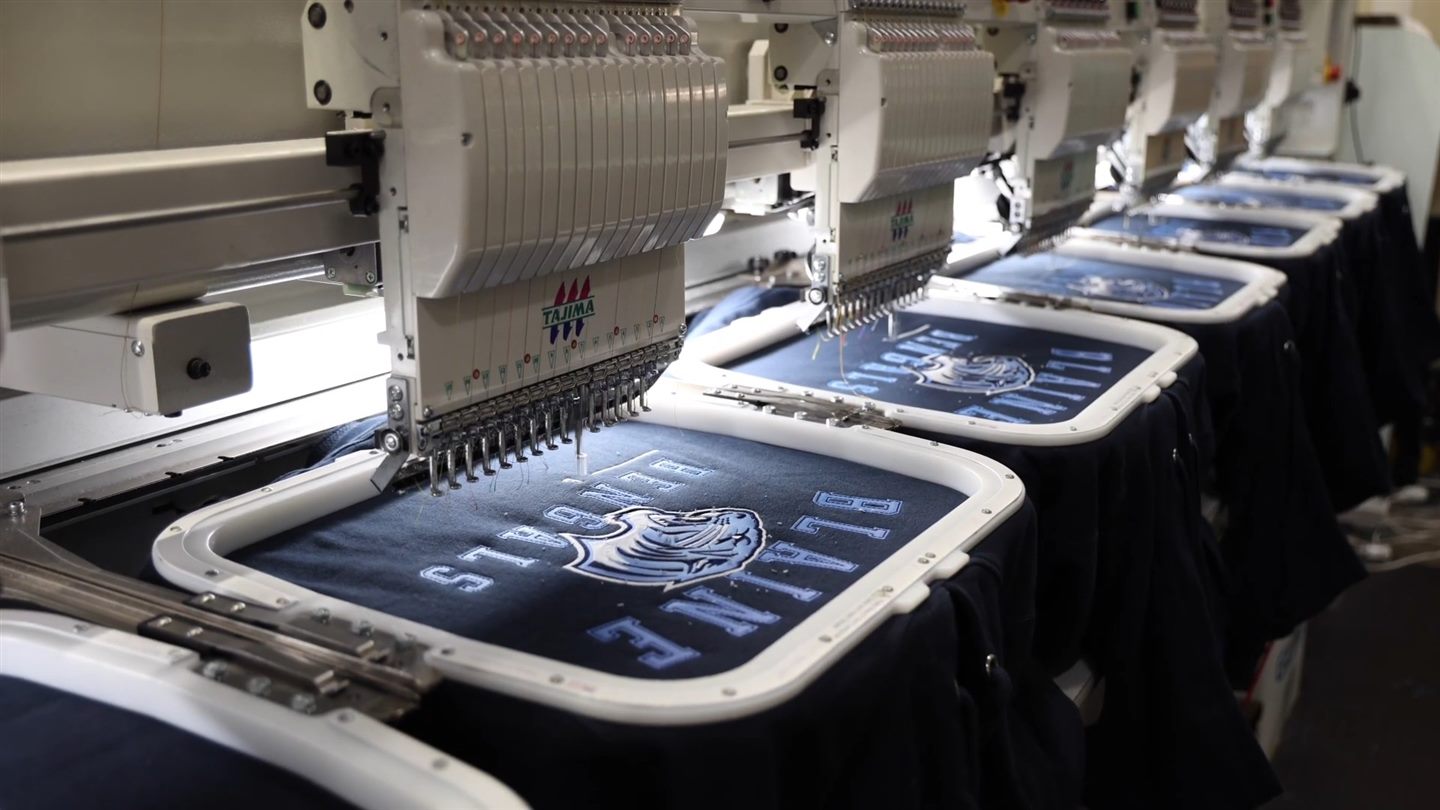 Blaine lettering being embroidered on jackets held in hoops