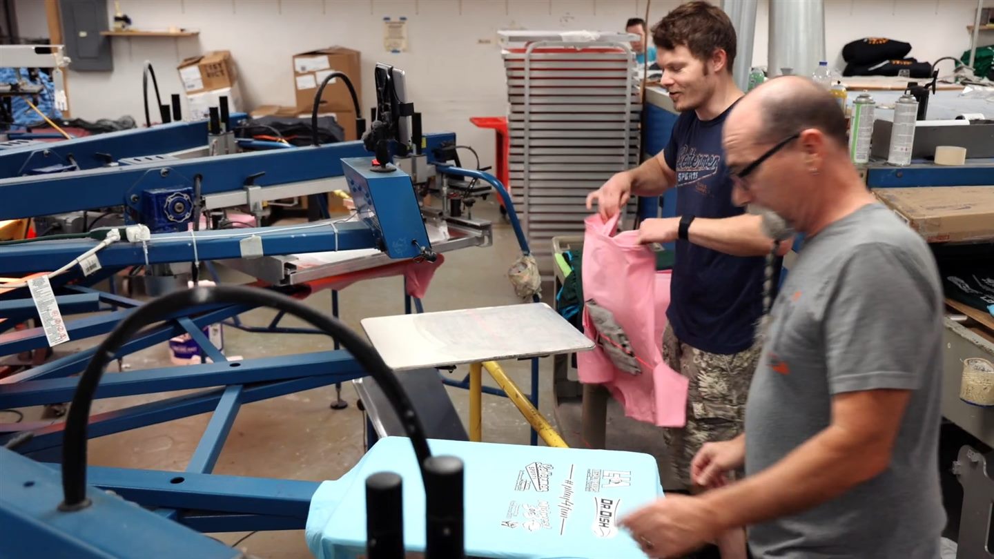 Two of our printers at a screen printing press